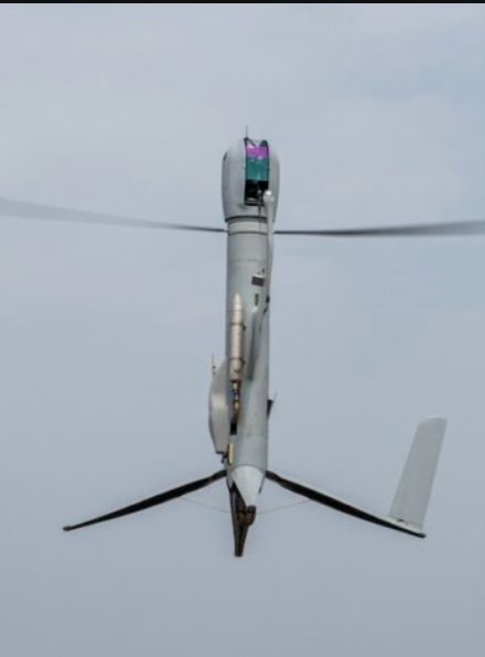 An unmanned helicopter drone seen from below in flight